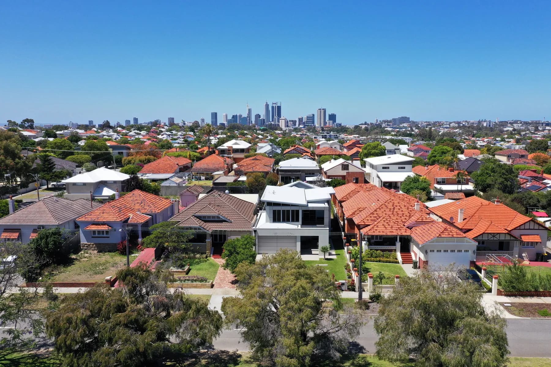 Aerial view of Perth suburban rooftops with the city skyline in the distance