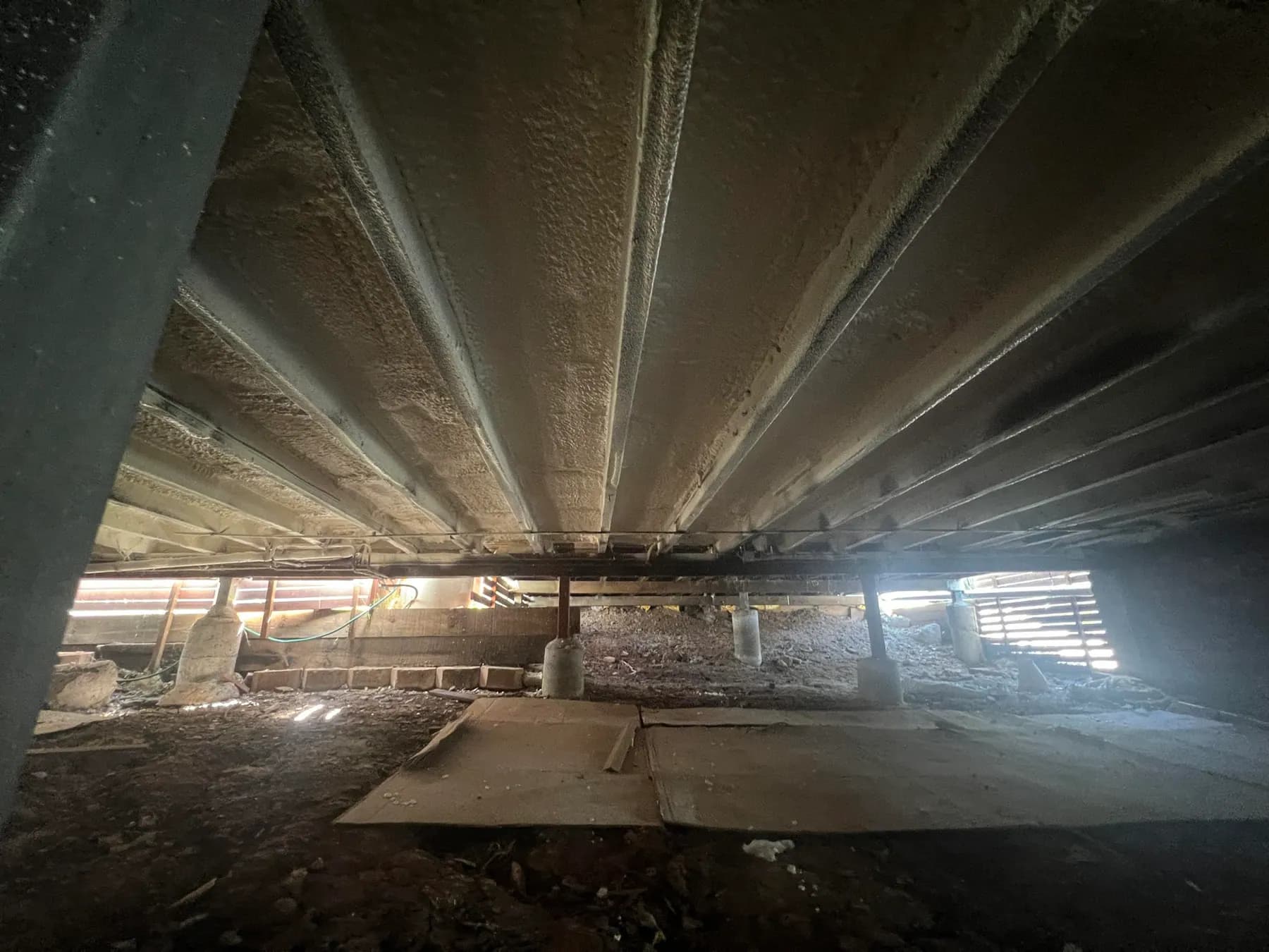 Underside of a timber floor sealed with spray foam insulation