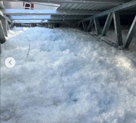 Installer blowing loose-fill insulation into a roof space