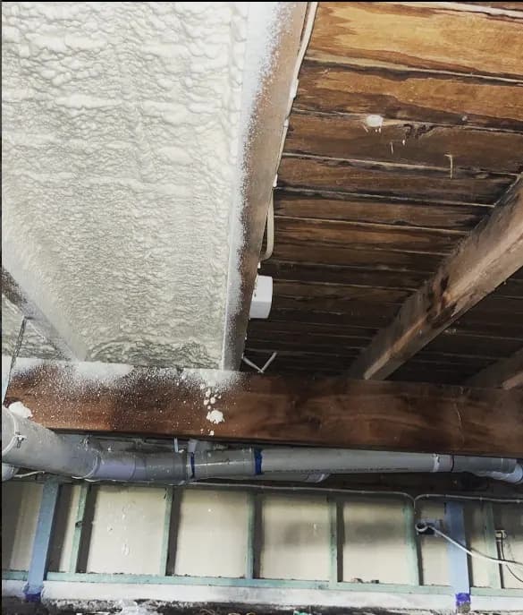 Installer applying closed-cell spray foam insulation