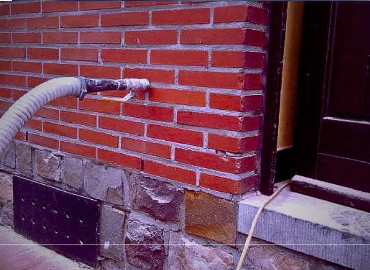 Glasswool insulation being injected into a brick cavity wall